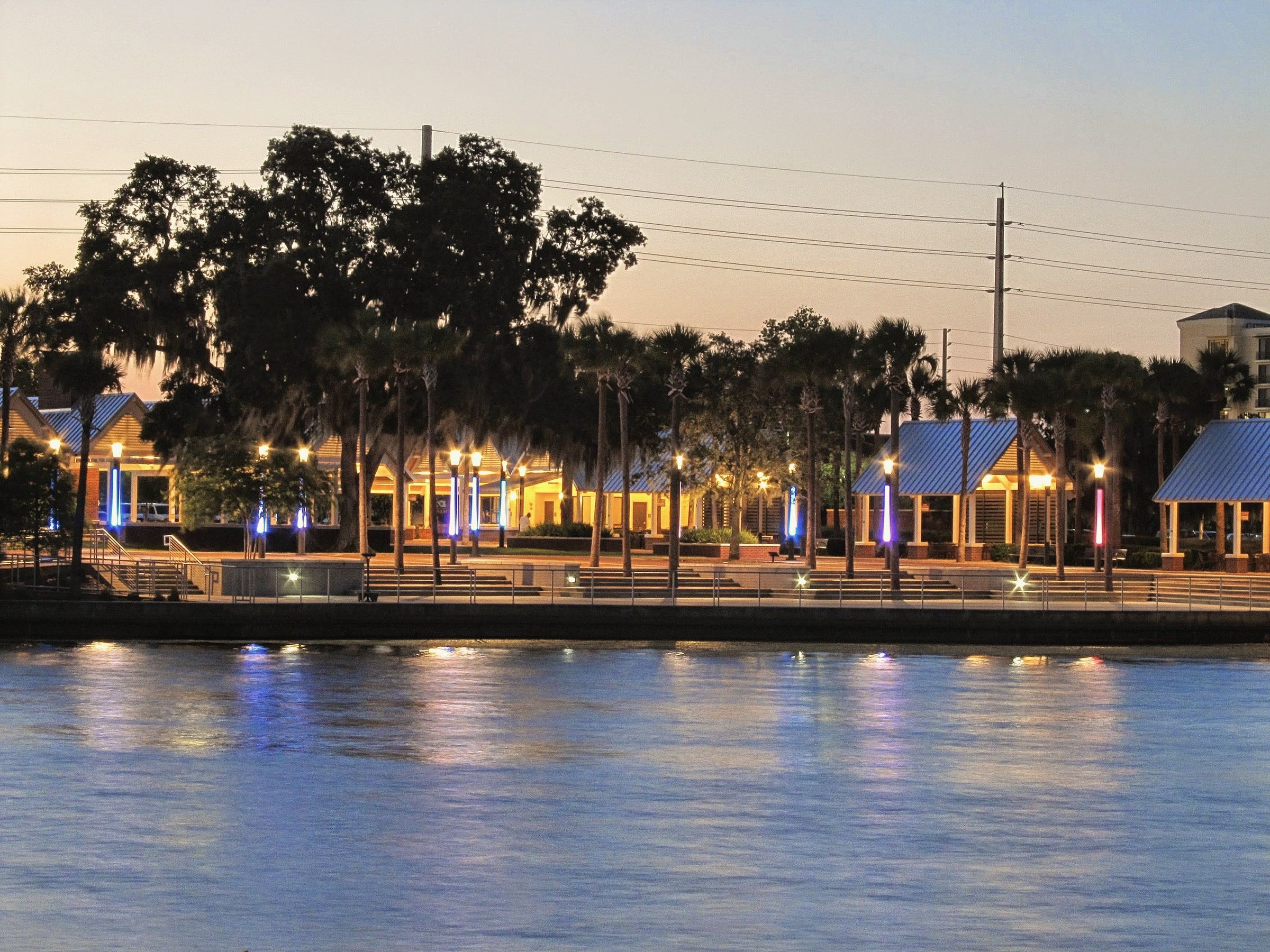 Kissimmee Lakefront Park at dusk, lights on along the water under the palms
