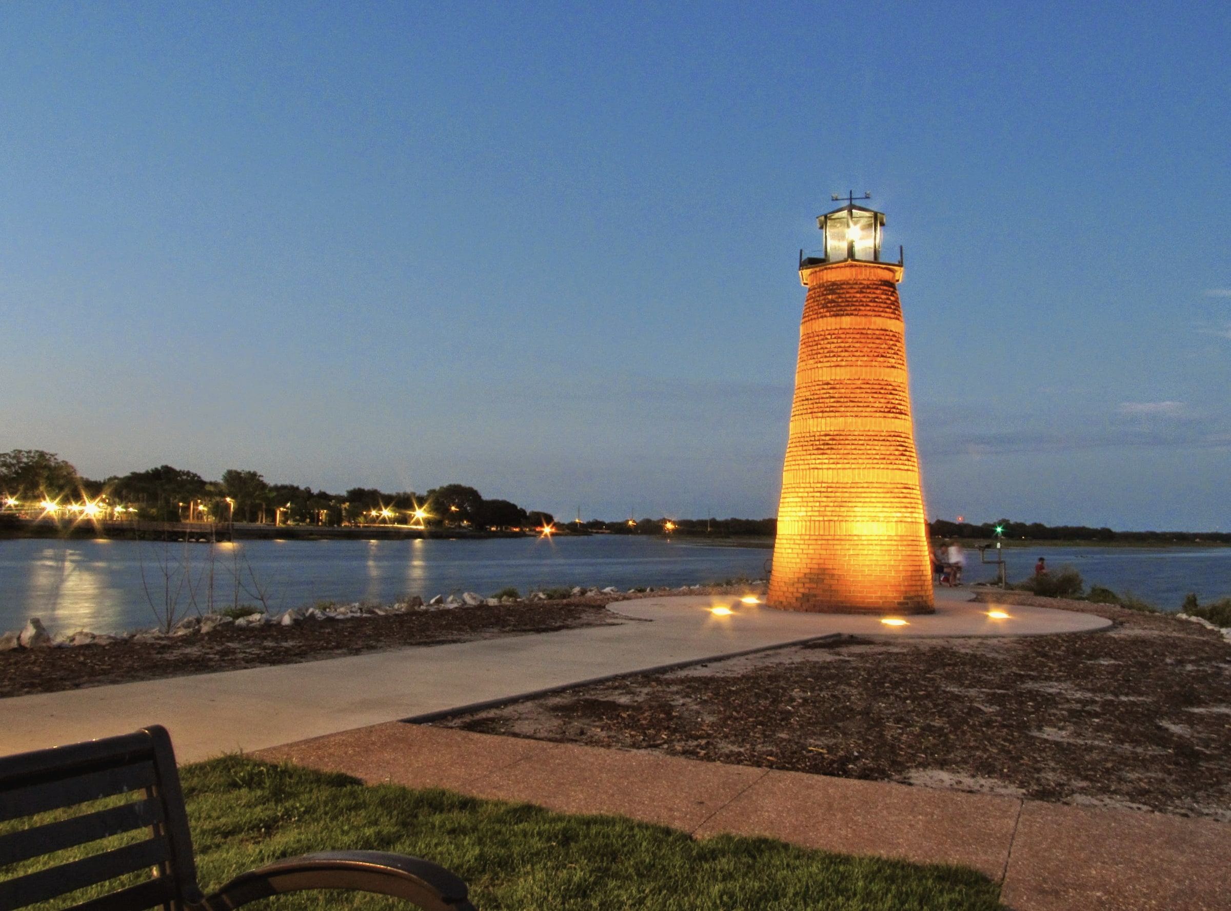 The Kissimmee Lakefront Park lighthouse lit at dusk on Lake Tohopekaliga