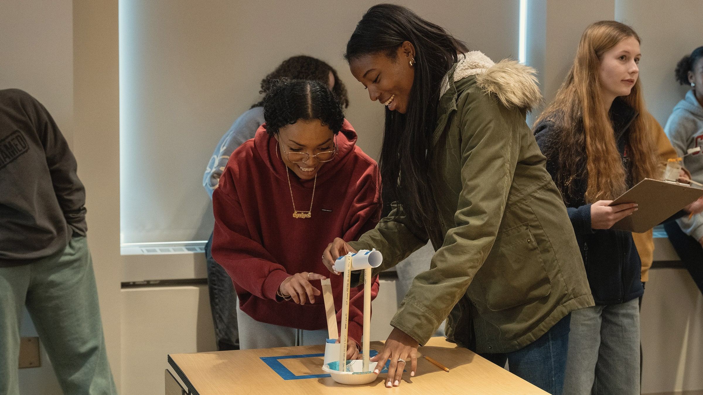 Two high school students building a test tower together at a STEM event